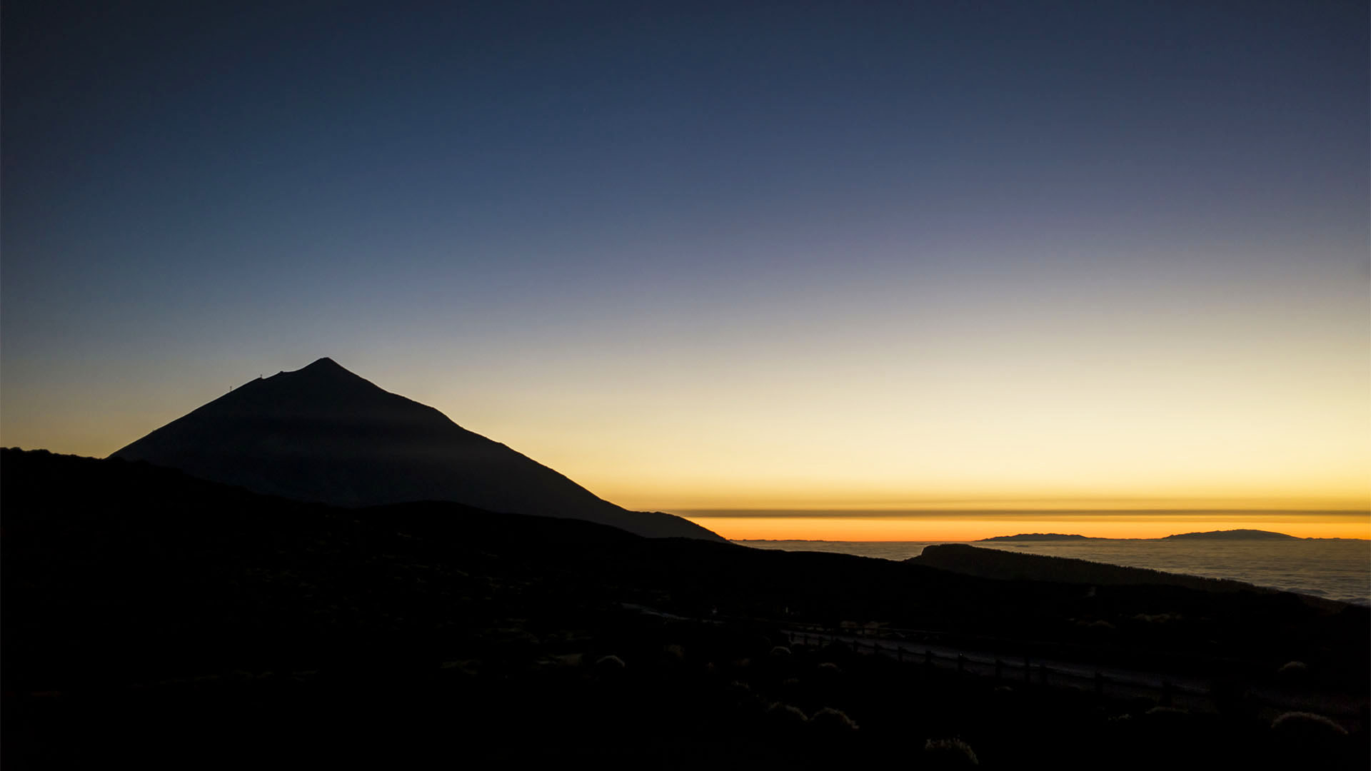 Neben der Silouhette des Teide versinkt die Sonne im Wolkenmeer aus dem die Gebirgszüge der Insel La Palma ragen. Blick vom Montaña de la Carniceria 2.367 m.