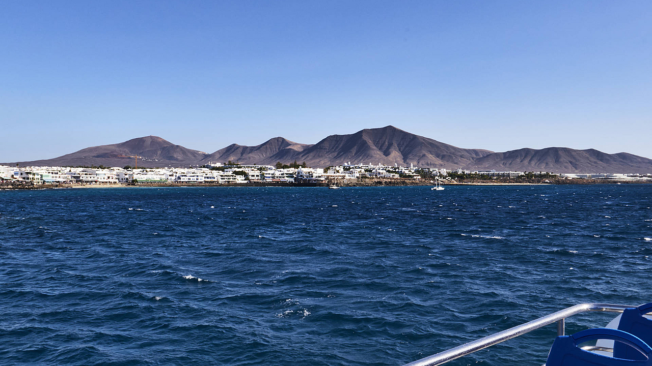 Einlaufen in den Hafen Playa Blanca auf Lanzarote – in der Ferne baut sich die Bergkette des Monumento Natural Los Ajaches.