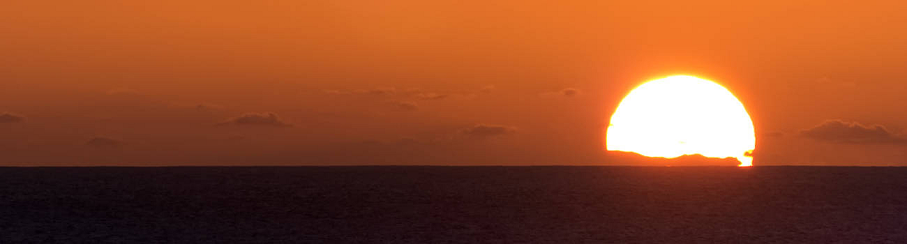 Gran Canaria im Gegenlicht der sinkenden Sonne zur Weihnachtszeit gesehen von El Cotillo.