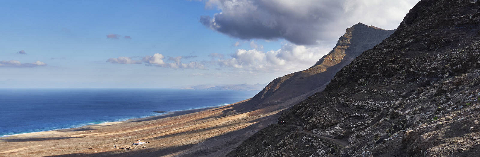 Wanderung Gran Valle - Cofete: Blick vom Degollada de Cofete (345 m) auf den Playa de Barlovento, die Villa Winter und den Pico de la Zarza (814 m).