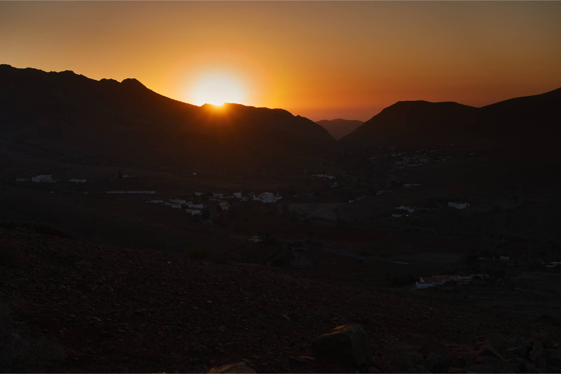 Hinunter nach Vega de Río Palmas bei Sonnenuntergang – der Feuerball versinkt hinter dem Höhenzug aus dem Pico Lima (629 m), Risco Blanco (618 m) und Pico de la Muda (535 m).