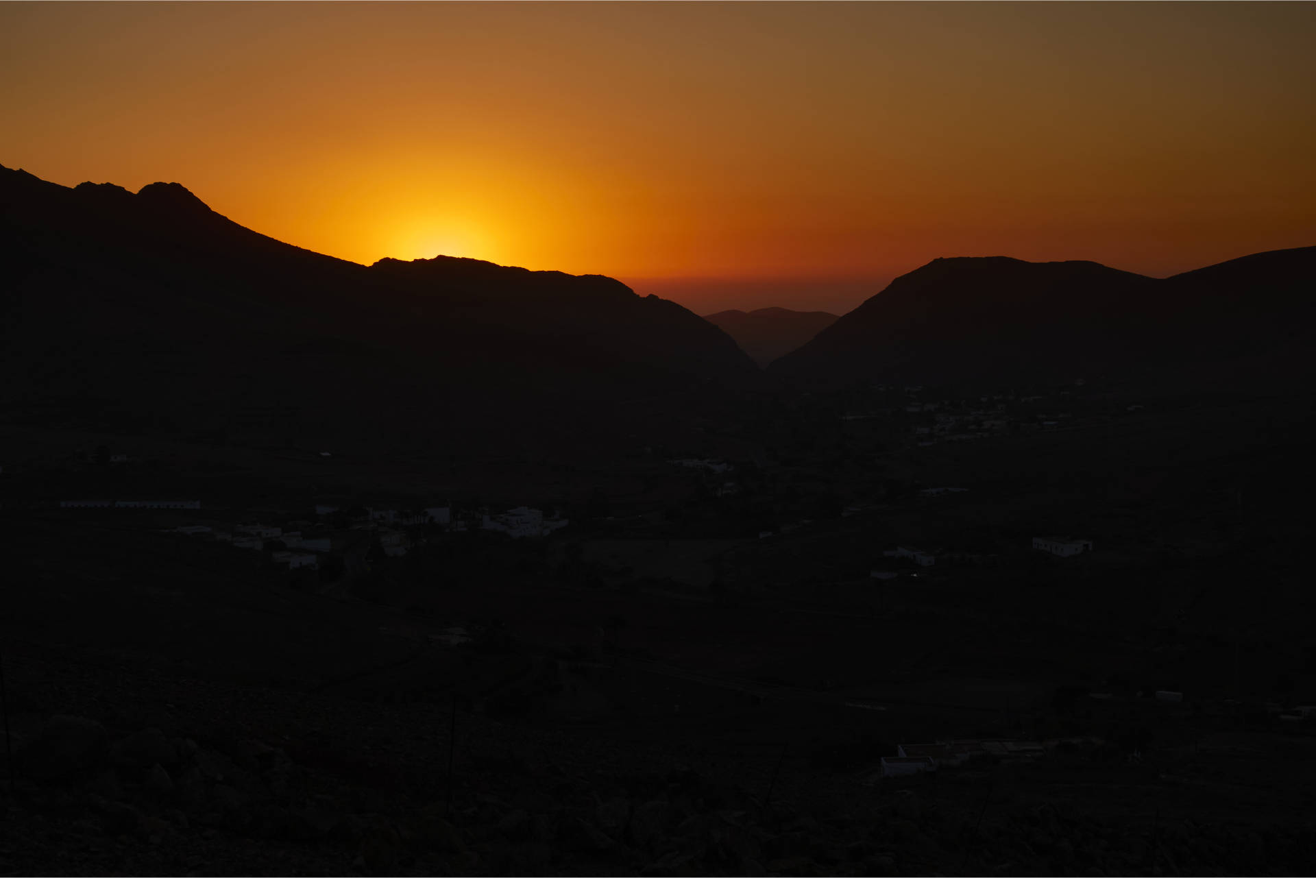 Hinunter nach Vega de Río Palmas bei Sonnenuntergang – der Feuerball versinkt hinter dem Höhenzug aus dem Pico Lima (629 m), Risco Blanco (618 m) und Pico de la Muda (535 m).