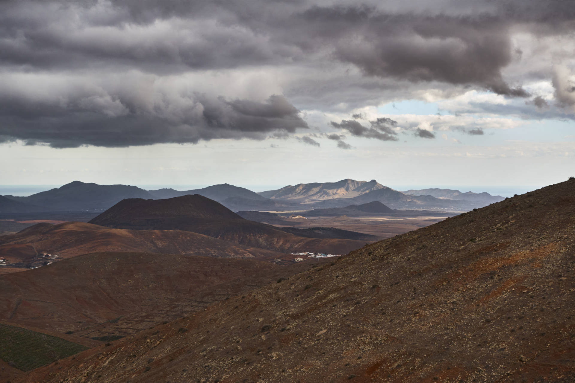 Blick vom Degollada Vista del Pueblo (566m) weit in den Süden – der markante und für die Ureinwohner bedeutende Montaña Cardón (694 m) liegt im Sonnenlicht.