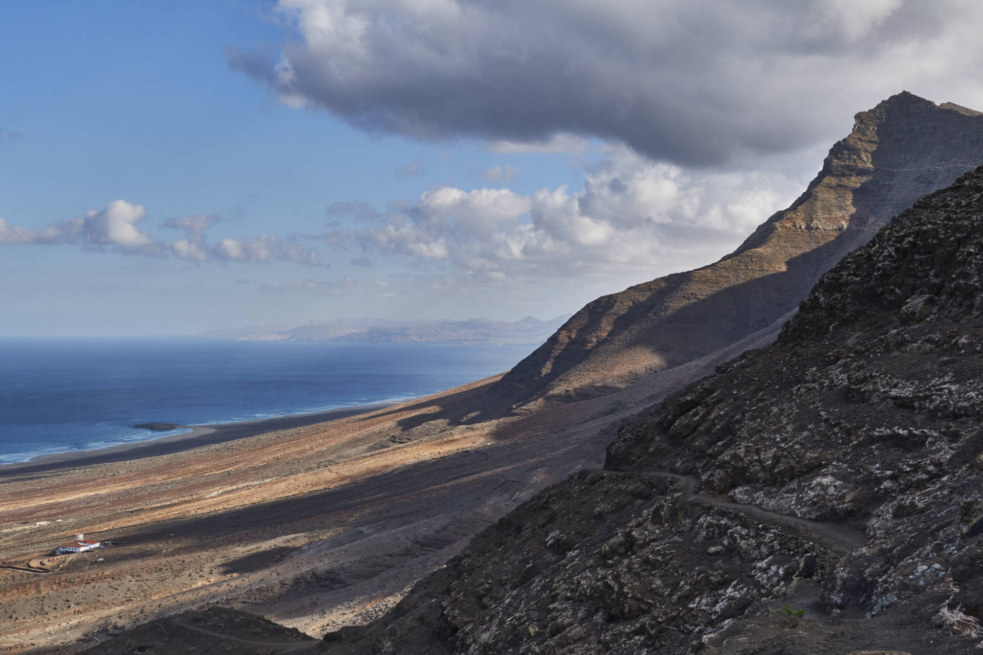 Wanderung Gran Valle - Cofete: Abstieg nach Cofete und Blick auf Playa de Cofete; Villa Winter und den Pico de la Zarza (814 m).