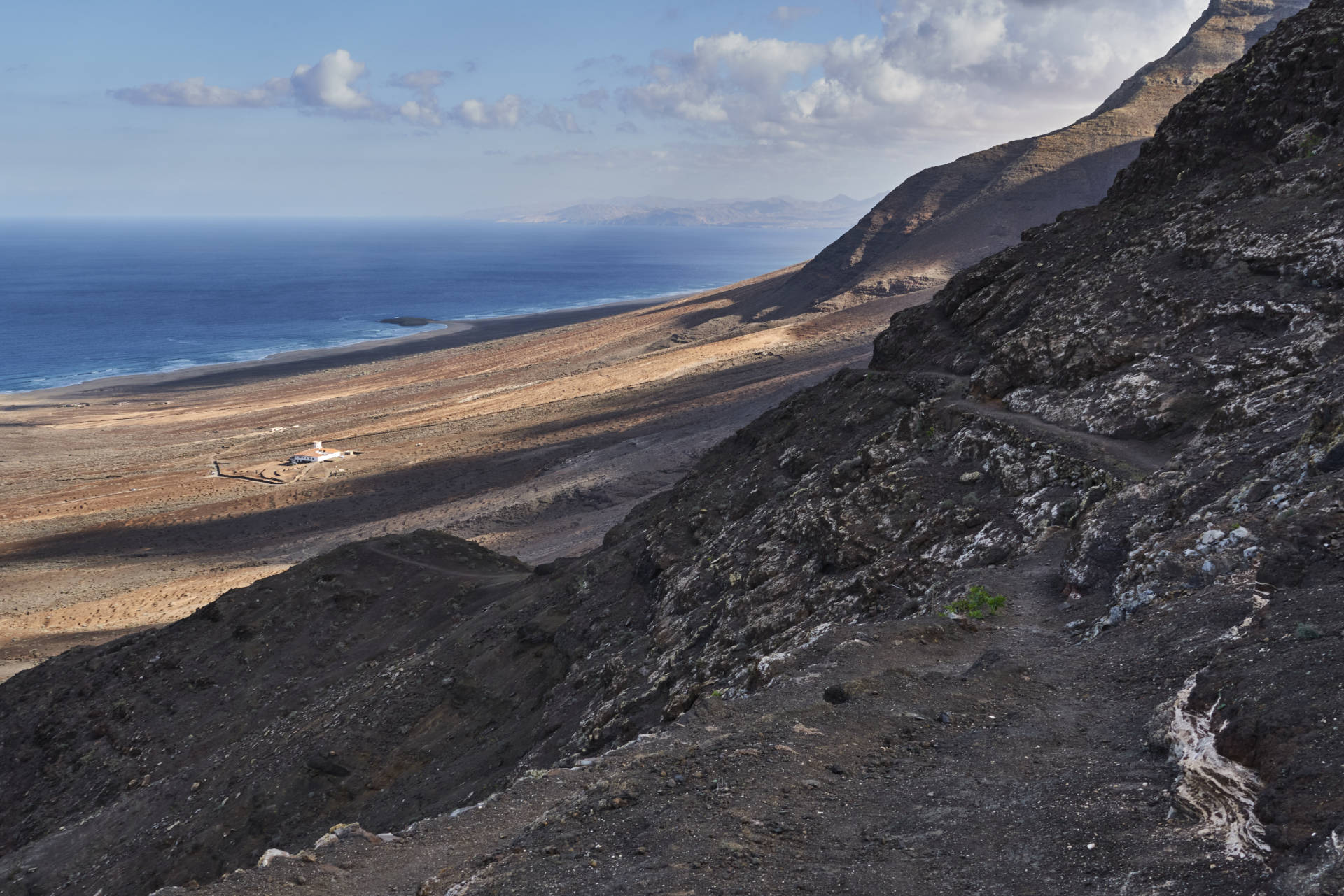 Wanderung Gran Valle - Cofete: Abstieg nach Cofete und Blick auf Playa de Cofete; Villa Winter und den Pico de la Zarza (814 m).