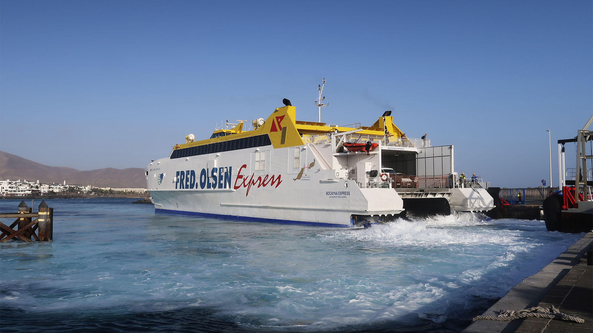 Die Fred Olsen Jet Fähre läuft in Playa Blanca Lanzarote ein. Die Jetmotoren sprudeln das Wasser des gesamten Hafenbeckens auf.