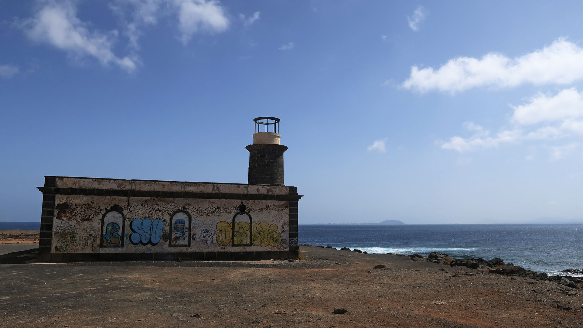 Der alte Leuchtturm Faro Punta de Pechiguera Lanzarote. Im Hintergrund zeichnet sich die Isla de Lobos ab.