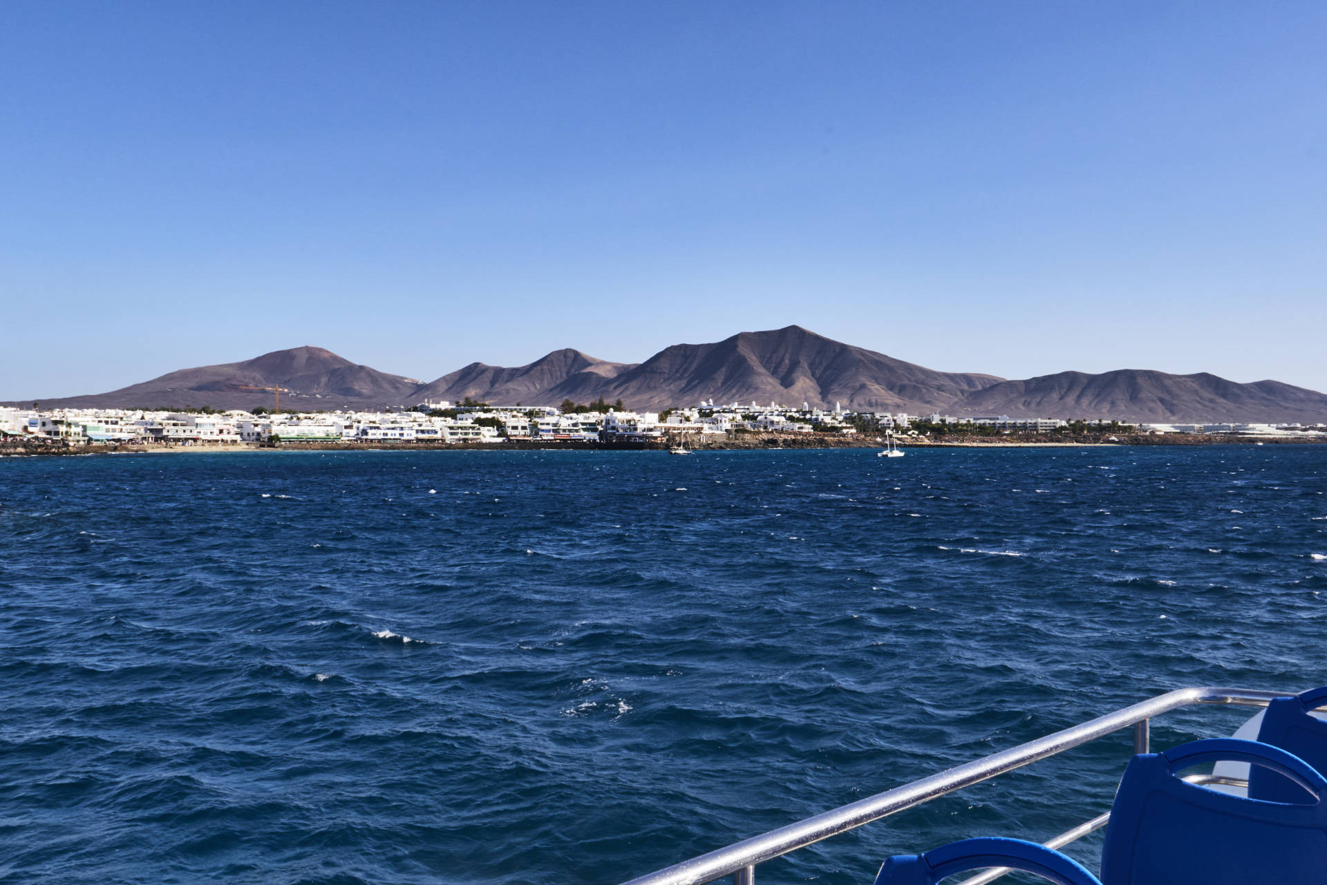 Einlaufen in den Hafen Playa Blanca auf Lanzarote – in der Ferne baut sich die Bergkette des Monumento Natural Los Ajaches.